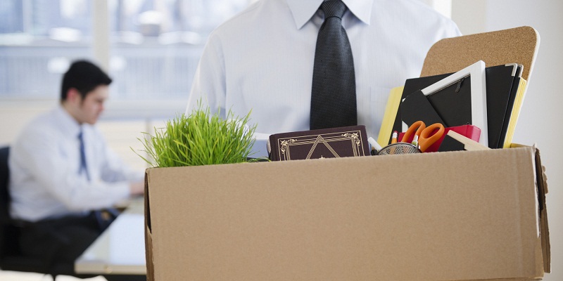 Fired Caucasian businessman carrying personal belongings